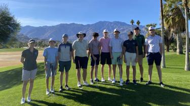 10 people stand on scenic golf course and pose for photo